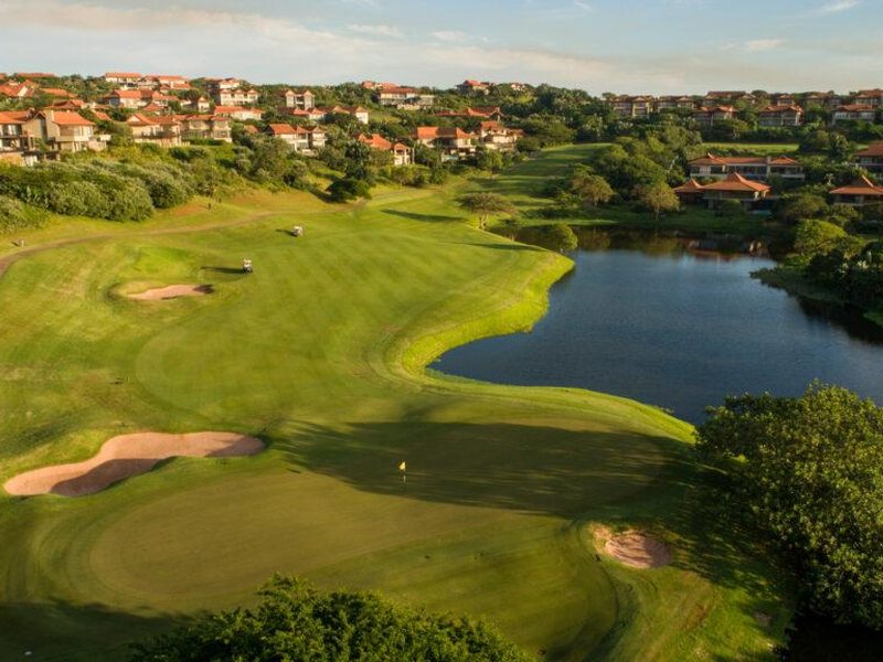 Aerial view of a green and lake at Zimbali Country Club