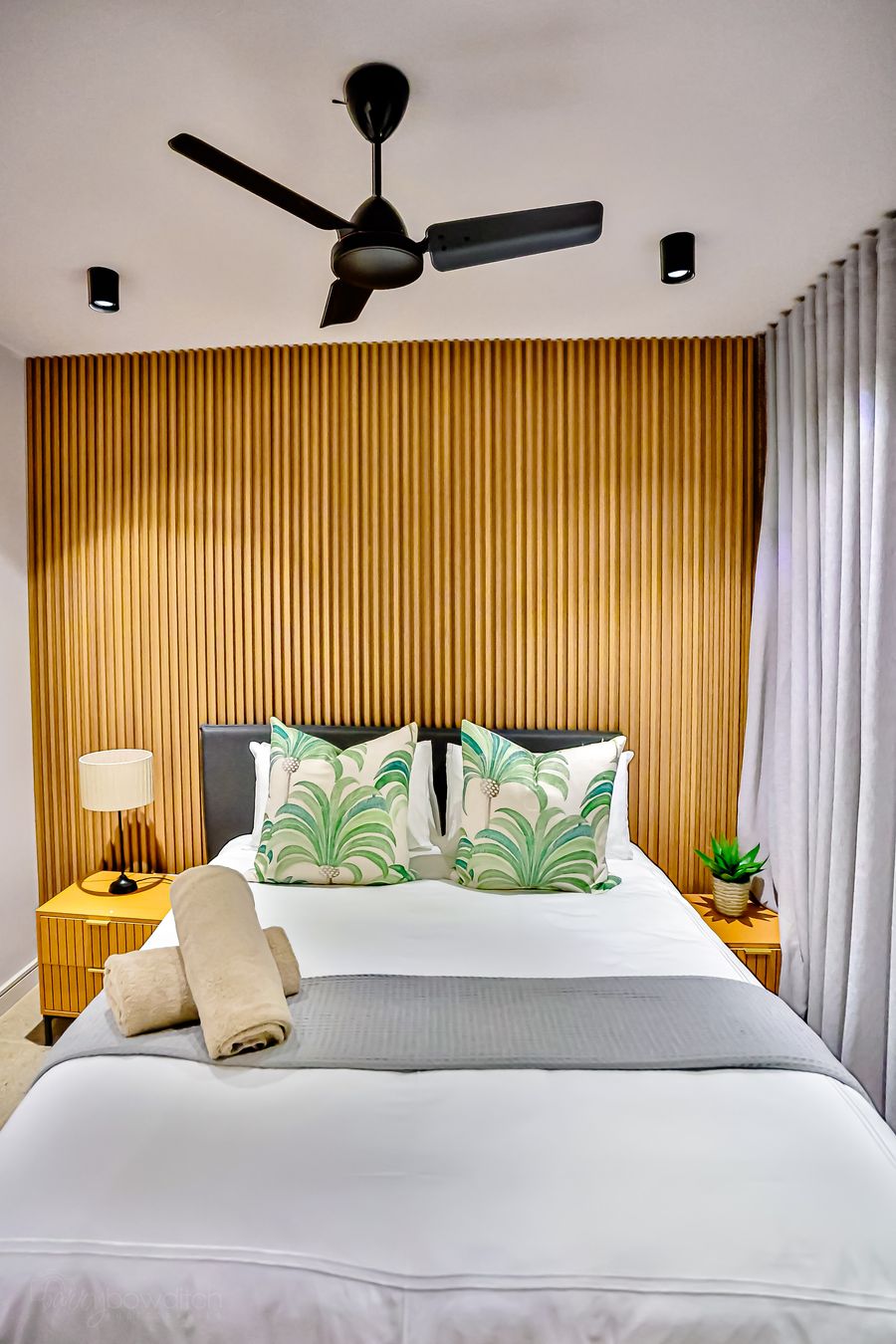 Main bedroom: queen bed against a timber feature wall
